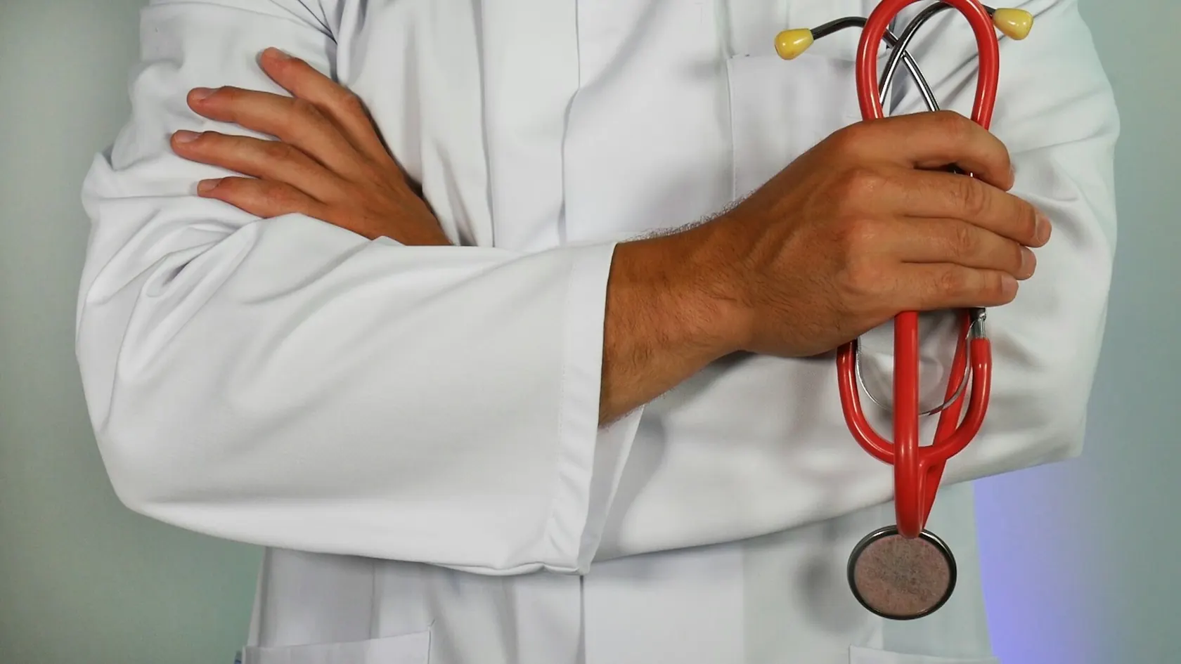 Médecin en blouse blanche tenant un stéthoscope rouge